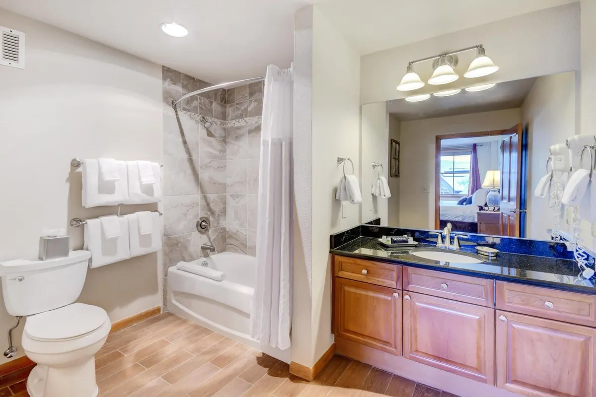 A modern, welcoming ensuite bathroom with a vanity, sink, bathtub, and shower stall. The clean lines and functional design invite relaxation after a day of mountain adventures.